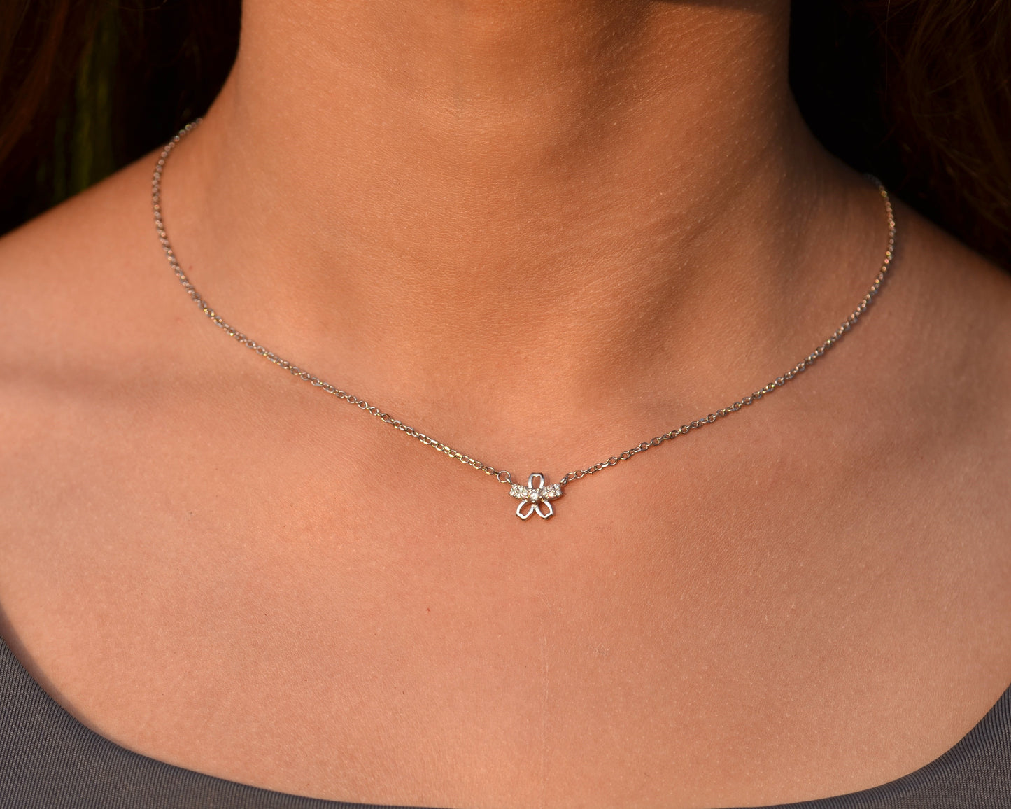 Necklace with a clover pendant worn by a person