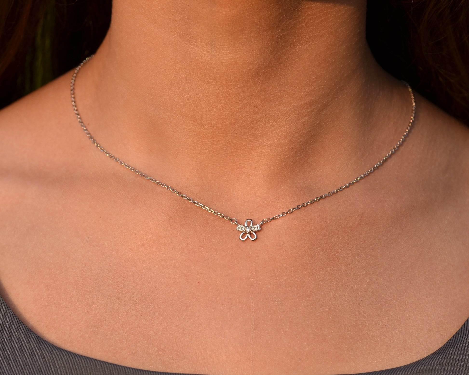 Necklace with a clover pendant worn by a person